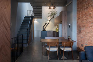 Nhà được bao phủ bởi nhiều lớp gạch thô và cây xanh