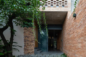 Nhà được bao phủ bởi nhiều lớp gạch và cây xanh