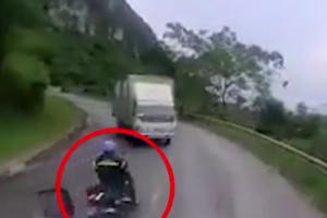 Clip: Lấn làn vượt ẩu ở khúc cua, người điều khiển xe máy "chui" vào gầm xe tải