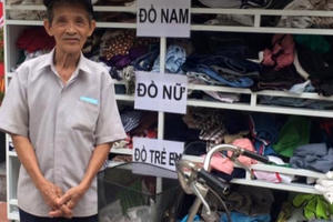 Người đàn ông tự mang sổ hộ nghèo đến trước quầy quần áo từ thiện