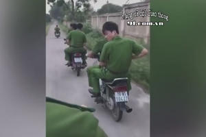 Nhóm người mặc sắc phục cảnh sát không mũ bảo hiểm, vi vu xe máy trên đường làng