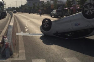 “Xế hộp” đâm gãy biển báo rồi lật ngữa trên đường, 4 người mắc kẹt