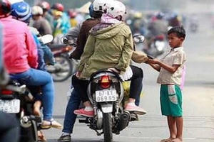 Bất chấp nắng cháy da, đám trẻ 'đóng chốt' xin tiền người đi đường