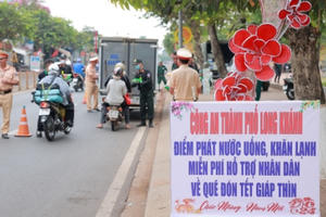 Công an TP Long Khánh phát nước suối miễn phí cho người dân về quê đón Tết