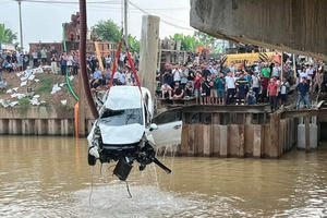 Va chạm xe máy, ô tô con đâm bay lan can cầu rồi lao xuống sông Đào