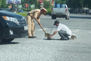 CSGT đội nắng quét đá dăm rơi trên đường