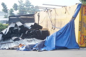 Bình Dương: Xe đầu kéo lật nhào, hàng chục tấn thép rơi xuống đường