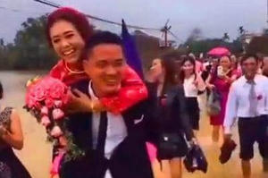 Đám cưới ngày bão: Chú rể cởi giày, cõng cô dâu lội nước xôn xao dân mạng