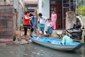 Ảnh: Triều cường liên tục đạt đỉnh, người Sài Gòn dùng xuồng đưa con đi học