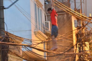 Hà Nội: Nam thanh niên "làm xiếc" trên dây điện khiến cả khu phố náo loạn
