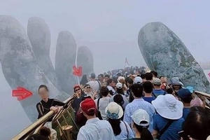 Bất chấp quy định, nữ du khách trèo vào bàn tay trên Cầu Vàng Bất chấp quy định, nữ du khách trèo vào bàn tay trên Cầu Vàng