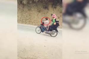 Hoảng hồn với cậu bé điều khiển xe máy "kẹp 4" dù... Chân chưa chạm đất!