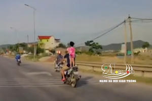 Kinh hãi cảnh bố để con gái đứng trên yên xe máy đi với tốc độ cao