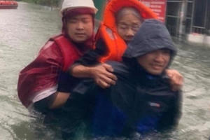 Dầm mình trong nước lũ cõng dân thoát khỏi những ngôi nhà giữa biển nước