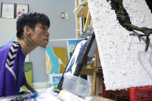 Chàng trai khuyết tật vẽ tranh bằng miệng