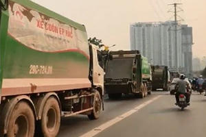 Hà Nội: Xe rác hiên ngang "rồng rắn" lấn làn xe buýt nhanh khiến giao thông tắc nghẽn