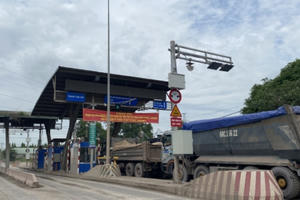 Hàng chục xe ben đồng loạt sử dụng tiền lẻ trả phí khi qua trạm vào mỏ đá Tân Cang