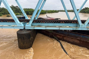 Lũ cuốn sà lan mắc kẹt dưới cầu đường sắt Bắc - Nam ở Quảng Trị