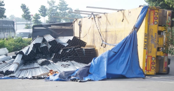 Bình Dương: Xe đầu kéo lật nhào, hàng chục tấn thép rơi xuống đường