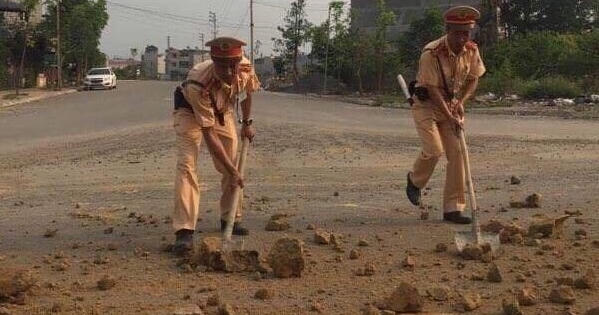 Cảnh sát giao thông số 11 "vào vai" công nhân môi trường cầm xẻng dọn đường