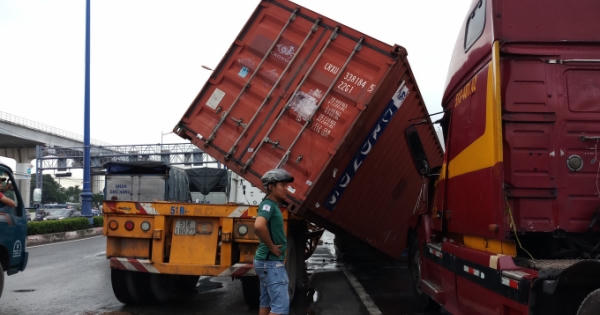 Thùng container rơi khỏi rơ mooc, đè lên xe đầu kéo chạy phía sau Thùng container rơi khỏi rơ mooc, đè lên xe đầu kéo chạy phía sau