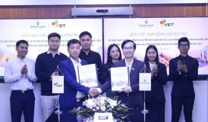 A group of people standing in front of a sign

Description automatically generated