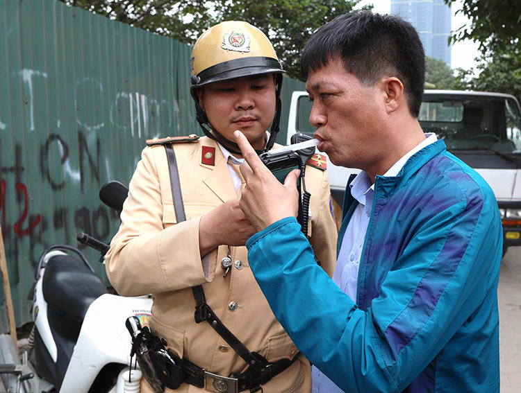 Cảnh sát giao thông Hà Nội kiểm tra nồng độ cồn của một tài xế. Ảnh: Ngọc Thành.