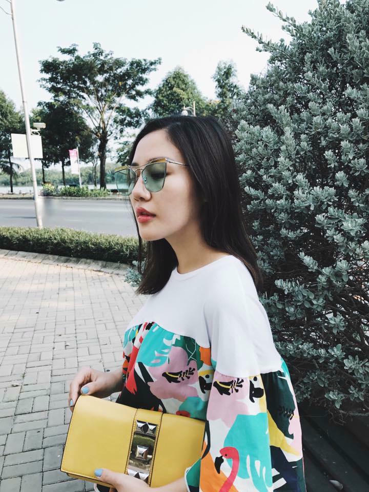 Lại một cô nàng nữa cho thấy kính mắt màu vẫn chưa ngừng hot. Chiếc clutch vàng tỏ ra cực kỳ "hợp rơ" với chiếc váy họa tiết cỏ cây mùa xuân của Văn Mai Hương.