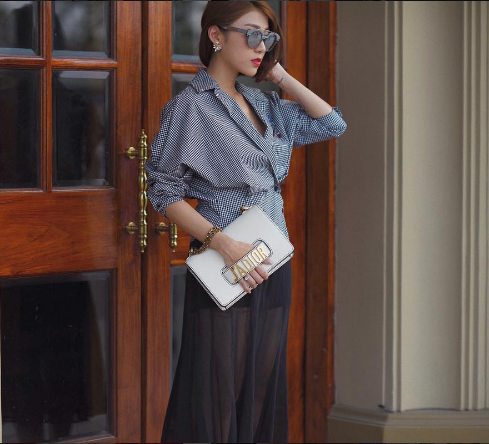 Túi xách J’ADIOR ngày càng được nhiều sao trong và ngoài nước diện để nhấn nhá thêm cho vẻ ngoài của riêng mình. Yumi Dương chọn cách phối chiếc túi cầm tay này với một chiếc áo thanh lịch và váy sheer xuyên thấu.