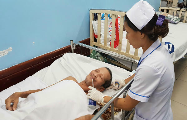 Bệnh nhân được chăm sóc suốt 3 tháng qua vì không thể làm thủ tục xuất viện dù bệnh đã ổn. Ảnh: Lê Phương.