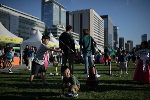 [Caption]Children play a traditional Korean game in Gwanghwamun square in Seoul on September 22, 2018. South Korea is marking the annual three-day Chuseok mid-autumn harvest festival.