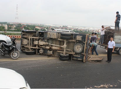 Chiếc xe tải gặp nạn nằm lật nghiêng trên cầu Thăng Long