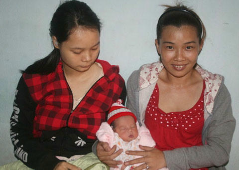 Mẹ ruột Bùi Thị Lan (trái) và mẹ nuôi Thu Hương (phải) bên đứa trẻ bị bỏ rơi.