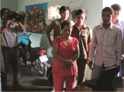 Bà Phụng (áo hồng) đang xem lại đoạn clip tắm cho cháu Ngân. Ảnh: NLĐO