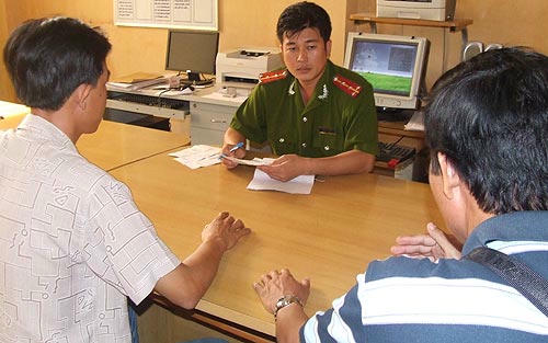 Điều tra viên ghi biên bản tiếp nhận các bức thư của bà Trần Thúy Liễu. Ảnh: NLĐ