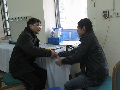 Bác sĩ Dũng (trái) đang khám cho một bệnh nhân bị u xương ở tay