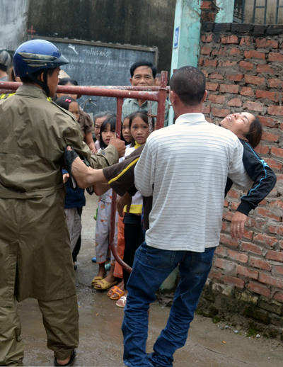 Vợ nạn nhân ngất lên ngất xuống, được người nhà đưa ra khỏi hiện trường.