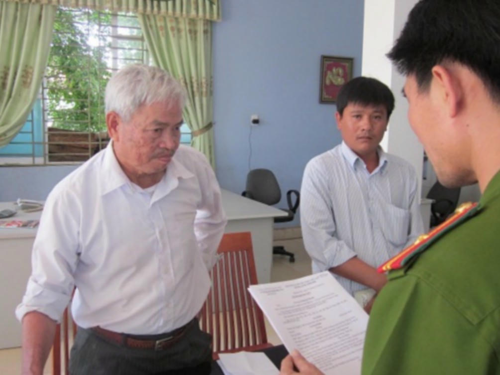 Đối tượng Lương Hạnh (áo trắng) bị cơ quan công an đọc lệnh bắt giam - Ảnh N.Ý