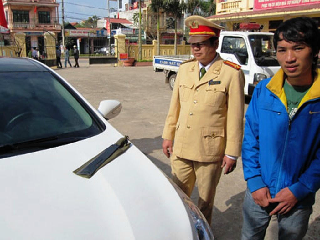 Đối tượng Đình cùng với xe ô tô chứa mã tấu.