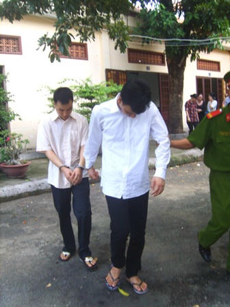 Hai bị cáo Long (người đi sau) và Hùng bị dẫn giải về trại giam.