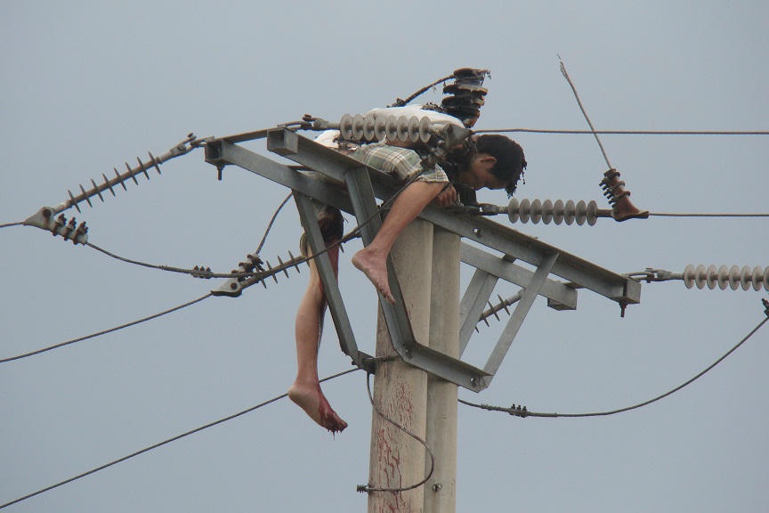 Nạn nhân nằm lơ lửng trên cột điện.