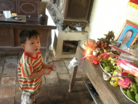 Cháu Hoan bên bàn thờ của mẹ.