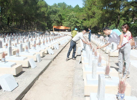 Ảnh 8:  Cán bộ, phóng viên thắp hương tại mộ phần các anh hùng, liệt sỹ ở Nghĩa trang Trường Sơn.