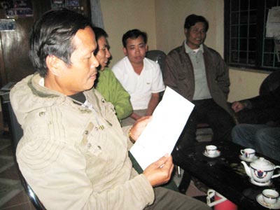 Ông chủ tịch xã Đinh Hợp đang đọc biên bản cam kết bỏ thuốc của một người dân trong xã.