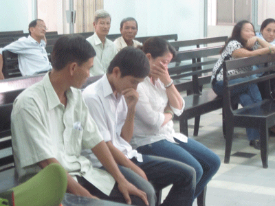 Duy (ngồi giữa) bên gia đình trong lúc chờ Tòa nghị án.