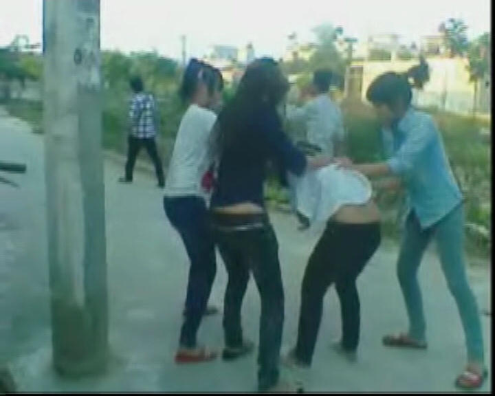 Em B. bị 3 đối tượng đánh hội đồng, xé quần áo làm nhục ngay canh cổng trường của Trung tâm giáo dục thường xuyên. (ảnh cắt từ clip).