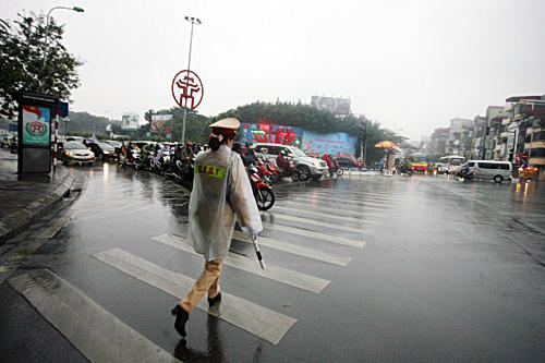 Thời tiết mưa gió nên các nữ CSGT phải mặc áo mưa làm nhiệm vụ