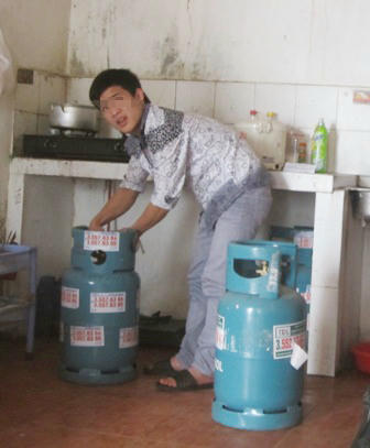  Một nhân viên tiếp thị  Gas không đồng phục đang kiểm tra van gas.