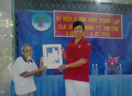 Ông Đồng tặng hình Bác Hồ cho hội người cao tuổi huyện Tịnh Biên.