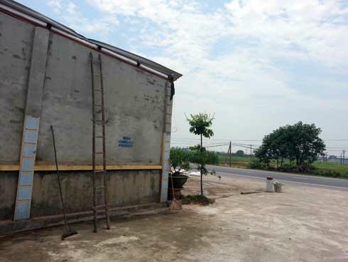 Mái tôn cao chừng 3 mét nằm cách mặt đường không xa là nơi người phụ nữ 35 tuổi bị ôtô hất văng lên, tử vong. Ảnh: T.Thịnh.